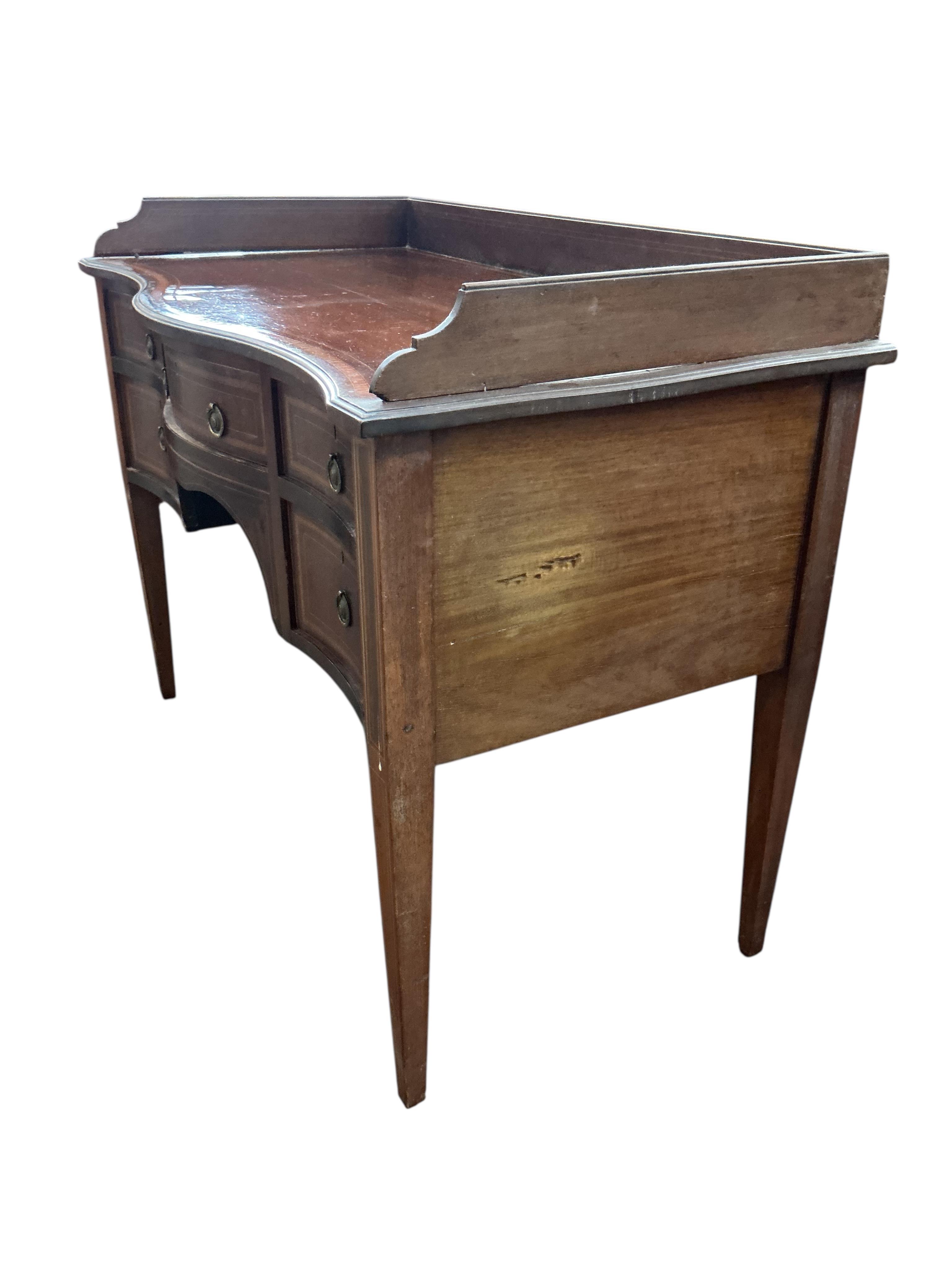 An Edwardian satinwood banded serpentine mahogany dressing table, on tapered legs, width 106cm, depth 54cm, height 82cm